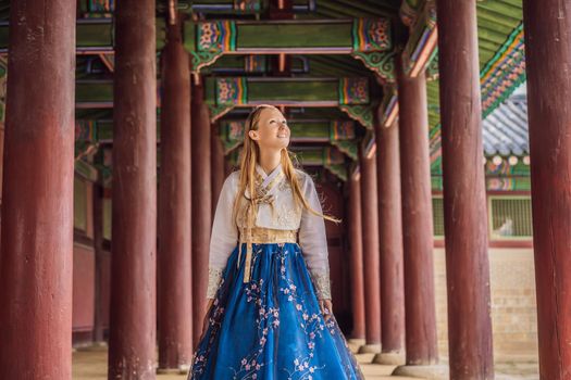 Young caucasian female tourist in hanbok national korean dress at Korean palace. Travel to Korea concept. National Korean clothing. Entertainment for tourists - trying on national Korean clothing