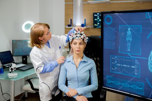 Doctor adapting neurology helmet during a brain scan procedure