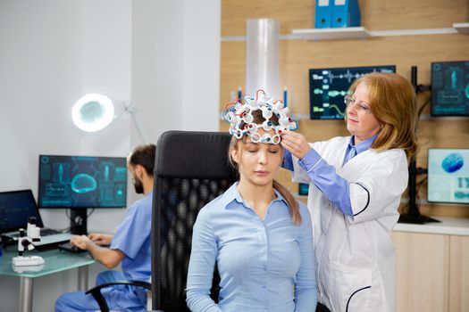 Doctor who puts brain waves scanning device on a female patient
