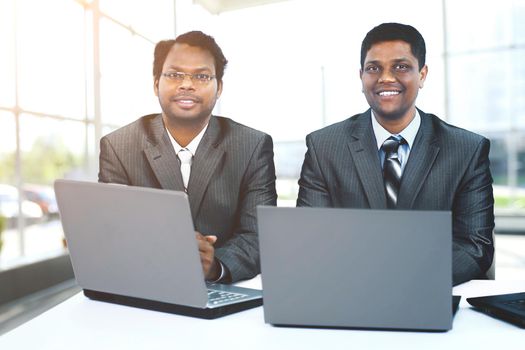 Interracial business team working at laptop in modern office
