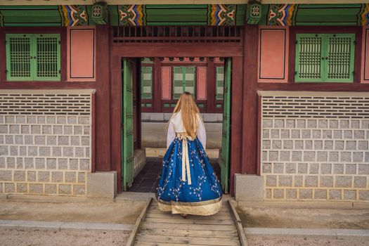 Young caucasian female tourist in hanbok national korean dress at Korean palace. Travel to Korea concept. National Korean clothing. Entertainment for tourists - trying on national Korean clothing