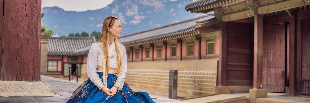 Young caucasian female tourist in hanbok national korean dress. Travel to Korea concept. National Korean clothing. Entertainment for tourists - trying on national Korean clothing BANNER, LONG FORMAT