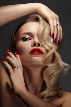 Beautiful Woman with Fashion Make-up and Blond Wave Hairstyle. Glamour American Diva Style with Brilliant Accessories