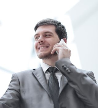 close up.smiling businessman talking on mobile phone