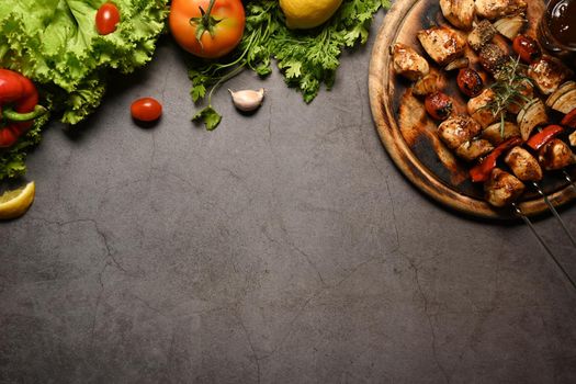 Grilled chicken skewers shish kebab on dark stone background. Top view, flat lay, copy space