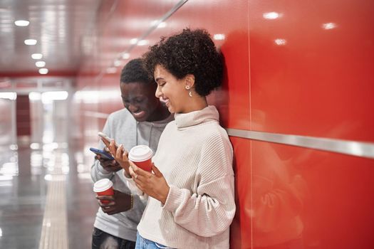 young couple with a smartphone waiting for a subway train .
