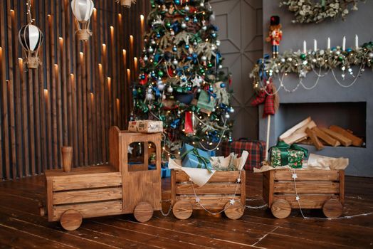 A full-length wooden steam train in a Christmas photo studio.