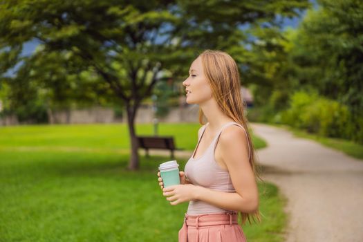 Dreamy young woman having a cup of coffee outside