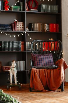 Wooden horse and rocking chair on the background of a bookcase