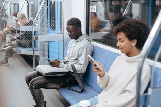 young people with smartphones traveling in the subway .
