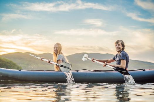 Man and woman swims on kayak in the sea on background of island. Kayaking concept.Kayaking concept with family of father mother at sea