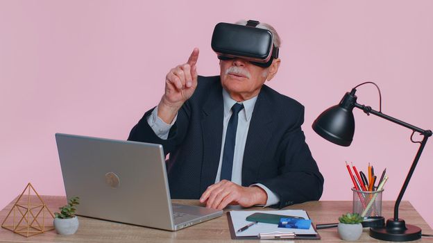 Senior businessman using headset helmet app to play simulation game, watching virtual reality video