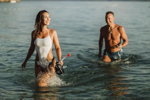 Couple Walking Through The Sea With Mask And Snorkel