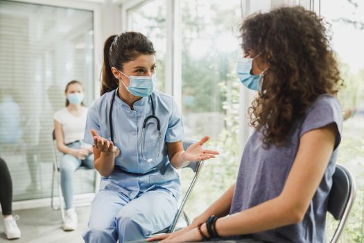 Nurse Talking To Teenager Girl Before Covid-19 Vaccine