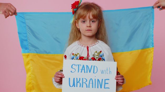 Upset toddler Ukrainian girl protesting war conflict raises inscription massage Hands Off Ukraine