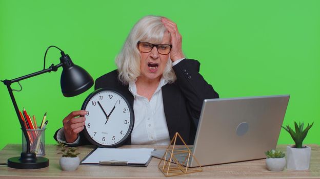 Senior businesswoman with anxiety check time on clock, running late to work being in delay deadline