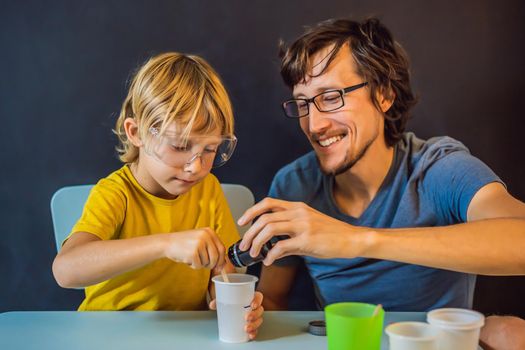 Father and son conduct chemical experiments at home. Home made slime