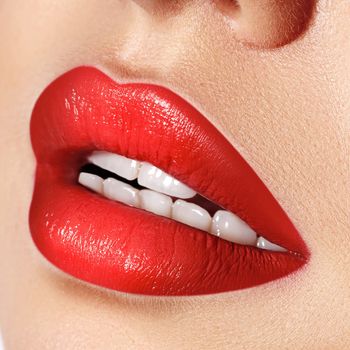 Close-up macro shot of female mouth. Sexy Glamour red lips Makeup with sensuality gesture. Red gloss lipstick