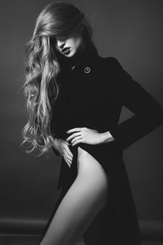 Sexy lady in Elegant Coat. Beautiful model in Fashion Jacket with Long Curly Hair. Erotic style. Black and White shot