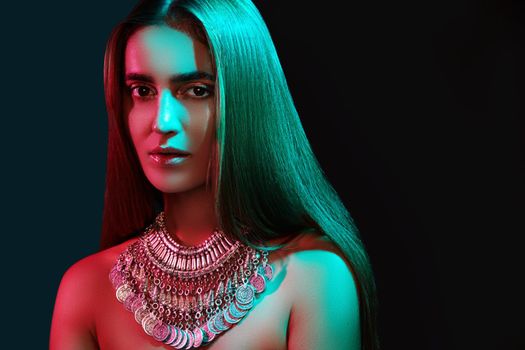 Beautiful woman in a necklace. Model in jewelry from silver. Beautiful indian jewellery. Bright lights