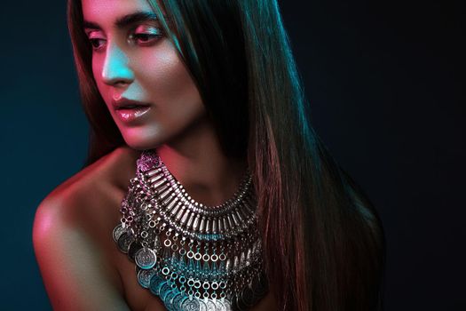 Beautiful woman in a necklace. Model in jewelry from silver. Beautiful indian jewellery. Bright lights