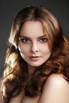 Beautiful young woman model with flying brown hair. Beauty with clean skin, fashion makeup. Make up, curly hairstyle