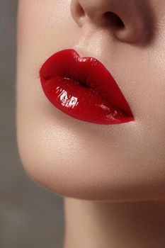 Close-up of female lips with bright makeup. Macro of woman's face. Fashion lip make-up with red lipgloss