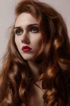 Beautiful ginger young woman with luxury hair style and fashion gloss makeup. Beauty closeup sexy model with red hair