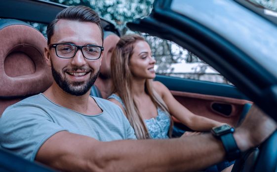 close up.stylish man with his girlfriend traveling in a convertible car.