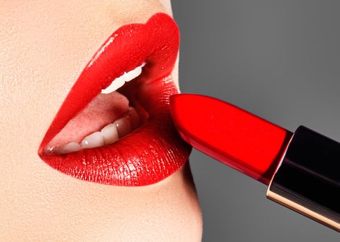 Close-up of woman's lips with fashion red make-up. Macro shot of beautiful make up on full lips. Choice lipstick