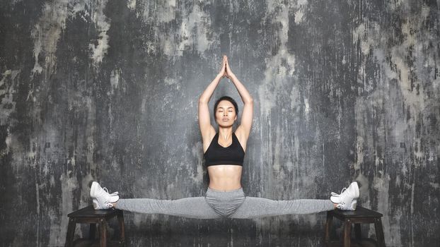 Beautiful young asian Woman Working Out, doing Pilates Exercise in Sportswear. Splits with Yoga Asana, Stretching