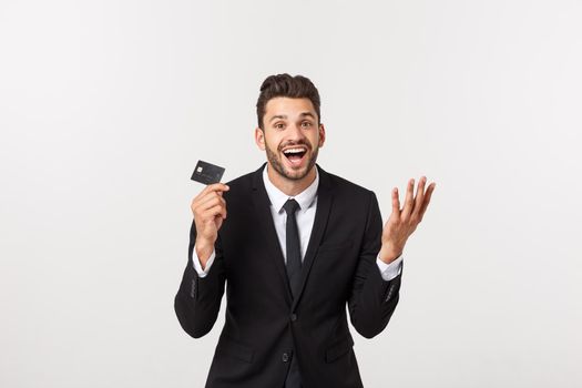 Surprised, speechless and impressed handsome caucasian businessman in classic suit showing credit card, say wow, standing white background astonished