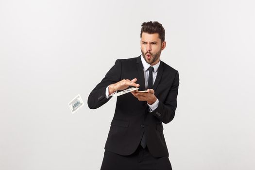 Portrait of a satisfied young businessman holding bunch of money banknotes isolated over white background.