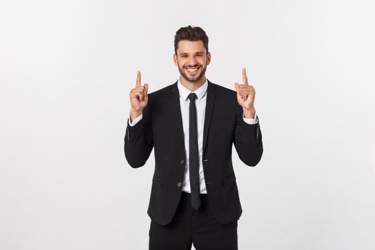 Young businessman celebrating his success over gray background.
