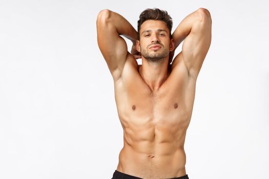 Sexy self-assured, handsome bearded young sportsman, athlete posing showing perfect body, six-pack abdominal abs, hold hands behind bragging strong muscles, smirk sassy, stand naked torso