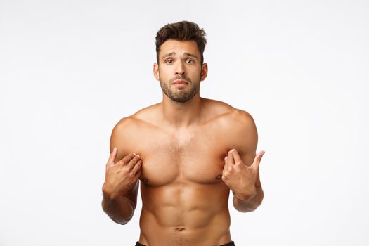 Cute upset, gloomy handsome shirtless sportsman with perfect body, six-packs abdominal abs, pointing himself, standing frustrated was accused something bad, posing distressed white background