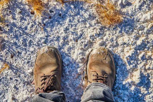 Boots standing in white powdered sand desert with yellow grasses