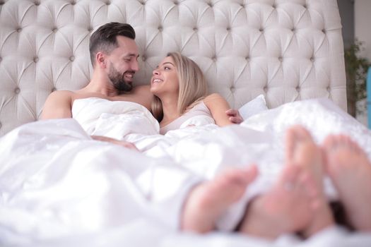 loving couple talking while lying on the bed