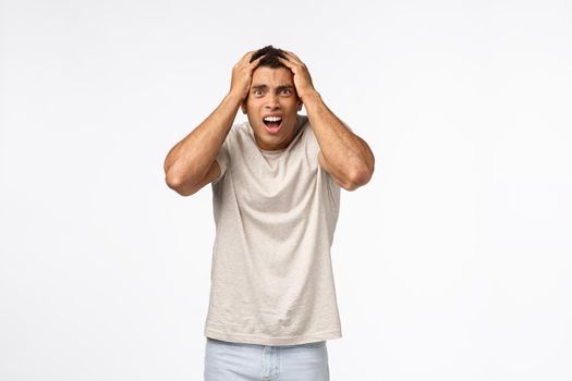 Man in panic feeling frustrated, alarmed, grab head staring upset camera, gasping drop jaw, cant believe failed test, grimacing bothered, lost competition, feel let down and gloomy, white background