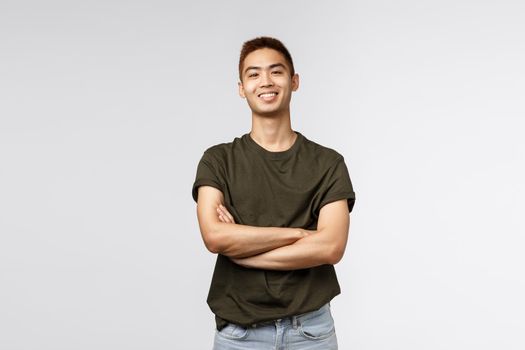 Good-looking taiwanese guy, teenage college student male, cross arms chest smiling proud and satisfied, show-off his ego, standing studio background satisfied and cheerful