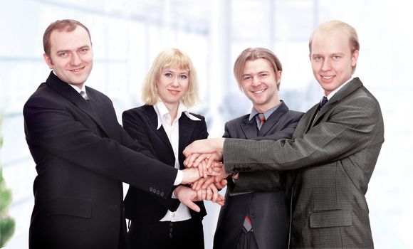 business team put their hands together.