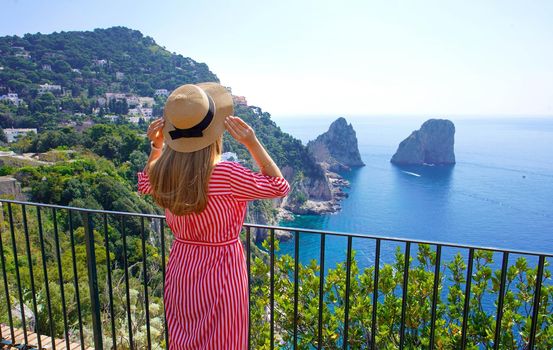 Tourism in Capri, Italy. Young beautiful fashion woman enjoying stunning landscape on Capri Island, Italy.