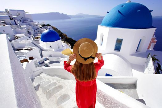 Holidays in Greece. Traveler girl enjoying panoramic view of Santorini. Wide angle.