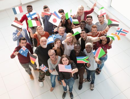 group of people with international flags looking up.