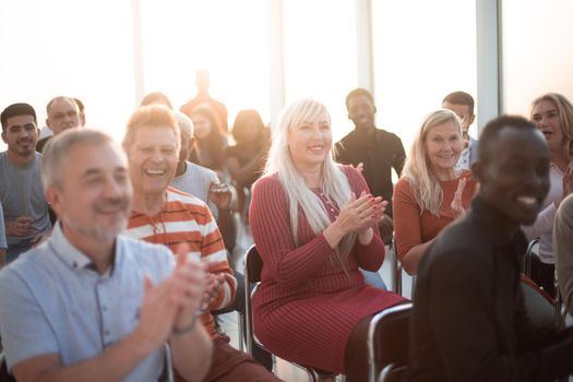 Smiling audience applauding at a business seminar
