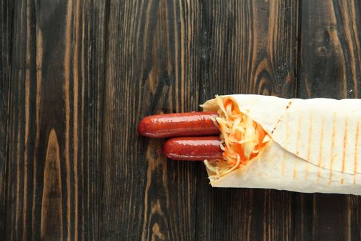 tender sausages in pita bread on wooden background.photo with copy space