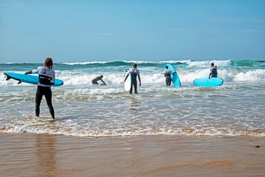 VALE FIGUEIRAS, PORTUGAL - March 29, 2022: Surfers getting surfers lessons at the atlantic ocean in Portugal