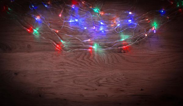 Christmas tree garland laid out on a wooden table
