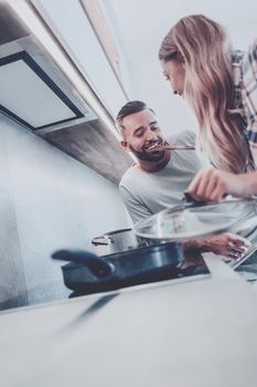 young husband and wife cook dinner together