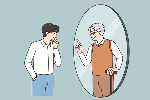 Young man look in mirror talk with old self